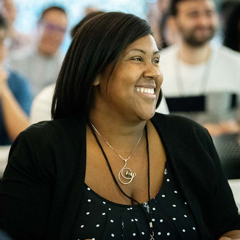 A woman smiles during a lecture